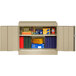 A sand-colored Tennsco metal storage cabinet with books and folders inside.