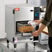 A semi-automatic ventless countertop deep fryer with a basket of fried food being removed.