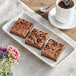 A white plate with square brownies, one topped with chocolate chips.