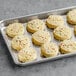 Preformed vegan birthday cake cookies with sprinkles on a tray.
