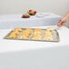 A Tablecraft Remington stainless steel tray holding croissants on a table.