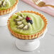 Two small fruit tarts with kiwi slices on top.