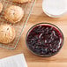 A bowl of Perfect Puree blueberry puree next to a cooling rack with cookies.