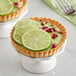 A Key Lime pie with a slice of lime on top.