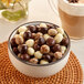 A bowl of Capora chocolate covered espresso beans on a table.