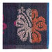 A close-up of a blue and pink jacquard fabric with a flower pattern.