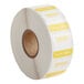 A roll of white and yellow Noble Products labels with the word "Tuesday" on them.