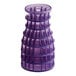 A purple plastic cone-shaped object with holes containing a stack of purple plastic cups.