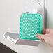 A person's hand holding a green and white Ourfreshe Cucumber Melon air freshener refill container.
