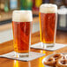 Two Libbey pub glasses of beer on a table.