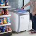 An Avantco curved glass top display freezer with a white and blue container inside.