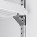 A metal shelf bracket on a white shelf in an Avantco merchandiser refrigerator.