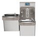 A Zurn Elkay stainless steel bi-level drinking fountain and bottle filler with a bottle on it.