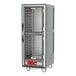 A gray Metro C5 heated holding cabinet with clear Dutch doors on wheels.