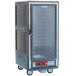 A large grey Metro C5 holding cabinet with a glass door and wheels.