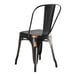 A black metal Lancaster Table & Seating chair with a black seat at a Lancaster Table & Seating outdoor table.