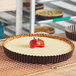 A round tart with a strawberry on top of it.