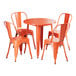 A Lancaster Table & Seating Alloy Series 30" Amber Orange standard height outdoor table with orange chairs.