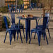 A blue metal table with four blue metal chairs on an outdoor patio.