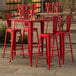 A Lancaster Table & Seating ruby red bar table with 4 chairs.