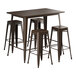 A brown metal Lancaster Table & Seating bar height table with four stools.