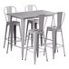A Lancaster Table & Seating nickel gray outdoor table with four white cafe barstools.