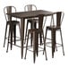 A brown metal Lancaster Table & Seating bar height table with four brown metal barstools.