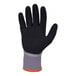 A close-up of a gray Ergodyne ProFlex 7501 freezer glove with a sandy nitrile palm coating and orange trim.
