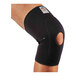A person wearing a black Ergodyne knee compression sleeve with open patella and anterior pad.