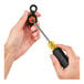 A hand holding a screwdriver with a yellow and black handle.