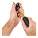 A hand using an Ergodyne tool tether to hold a black screwdriver.