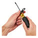 A hand holding a small black tool being tethered.