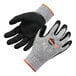 A pair of black and white Ergodyne ProFlex warehouse gloves with orange trim and text on the palm.