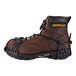A brown Caterpillar work boot with black Ergodyne spikeless traction device straps.