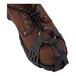 A brown leather boot with a Ergodyne TREX spikeless traction device on it.