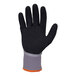 A close-up of an Ergodyne ProFlex medium freezer glove with a sandy nitrile palm and orange trim.