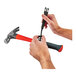 A pair of hands using Ergodyne Squids tool tethers to hold a hammer and a screwdriver.