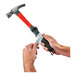 A person's hands using an Ergodyne Squids 3 lb. Wrist Lanyard Kit to tether a hammer.