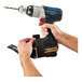 A person using an Ergodyne Squids power tool trap to tether a power drill.