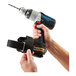 A person using an Ergodyne Squids Power Tool Trap to tether a drill.