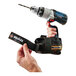 A hand using an Ergodyne Squids power tool trap to tether a power drill.