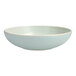 A white stoneware pasta bowl with a light blue rim.