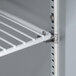 A white metal shelf inside a Traulsen stainless steel sandwich prep table.