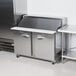 A Traulsen stainless steel refrigerated sandwich prep table with left and right hinged doors.