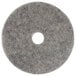 A grey circular Scrubble floor pad with a hole in the center.