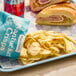 A blue tray with a Nantucket Crisps bag of salt and vinegar potato chips and a sandwich.