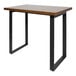 A BFM Seating black powder-coated steel loop frame bar height table base with a wood table top.