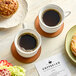 A table with Green Mountain Coffee and pastries including a muffin with nuts on top.