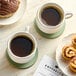 A cup of Green Mountain Coffee on a table with pastries.