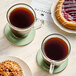 A glass cup of Green Mountain Coffee with a pastry on a table.